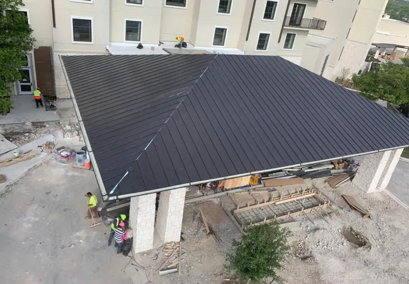 Metal roofing installation team working on a commercial building in Silvis